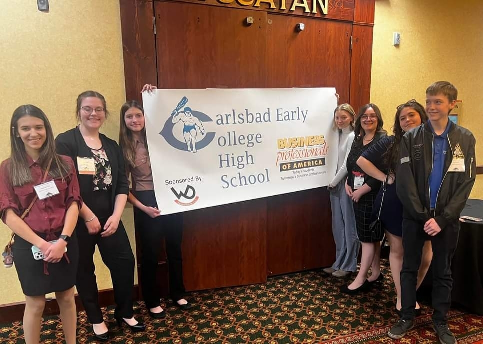 BPA students at State Competition pose with banner