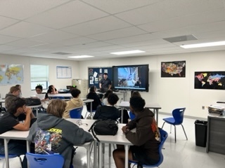 Students  in classroom watch presentation by visiting filmaker